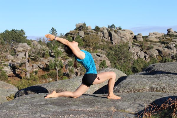 Frau beim Yoga im Klettergebiet mit Felsen im Hintergrund